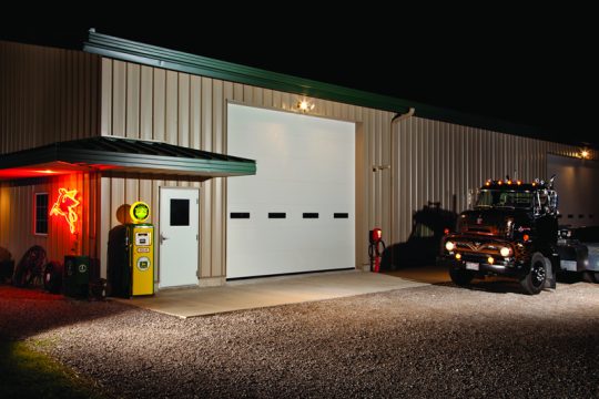A large White closed commercial garage door at hangar.